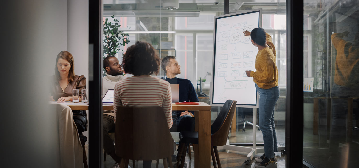 Woman using whiteboard in team meeting